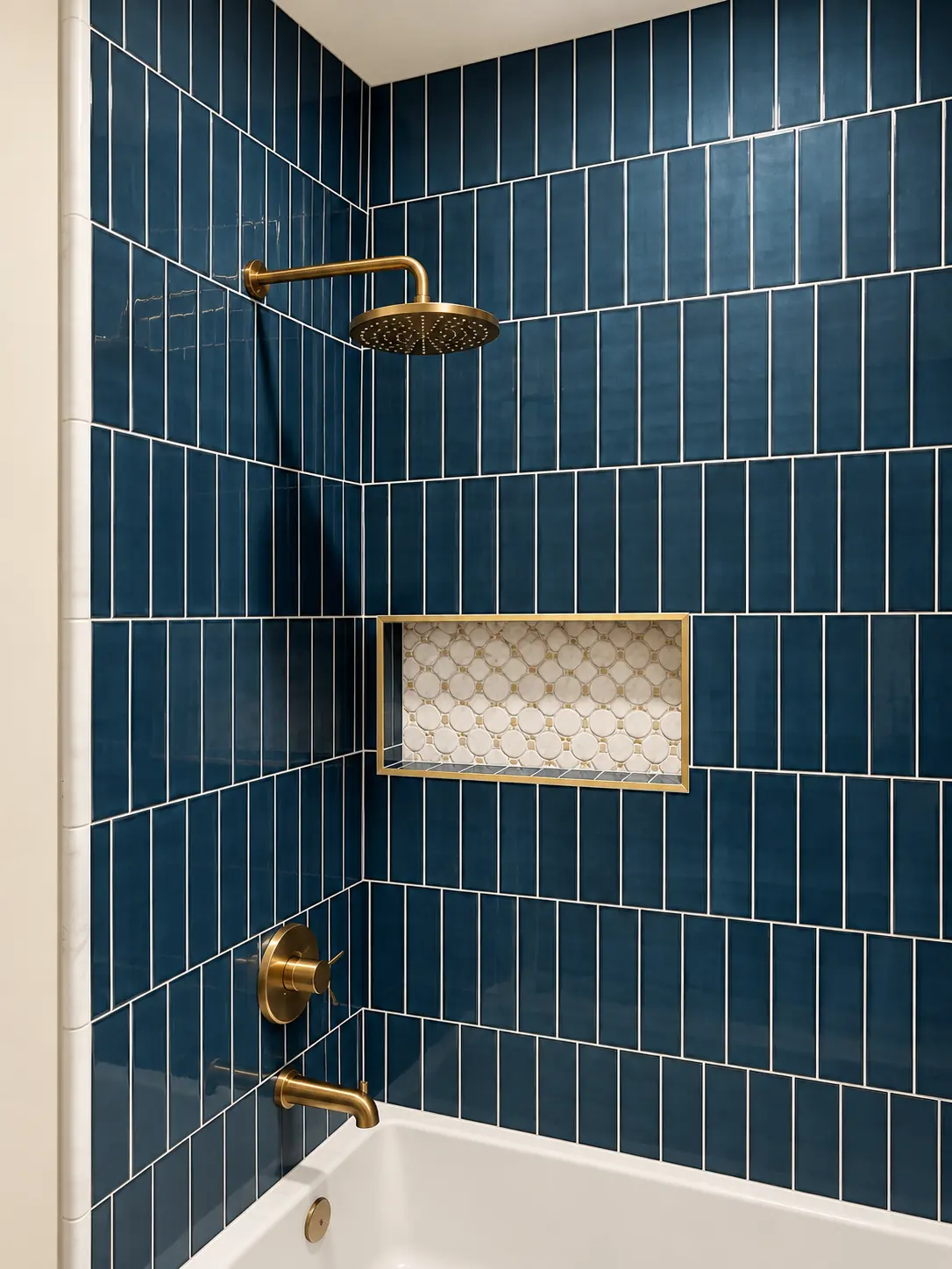 Blue tile shower niche with marble mosaic and brass rain head